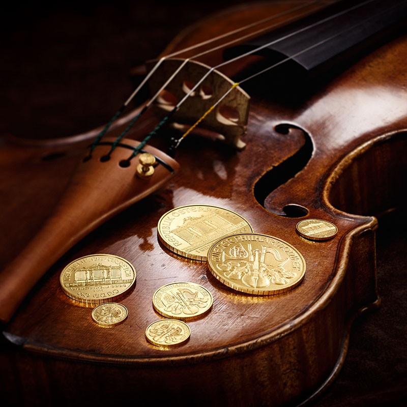 Austrian Philharmonic gold coins elegantly displayed on a violin